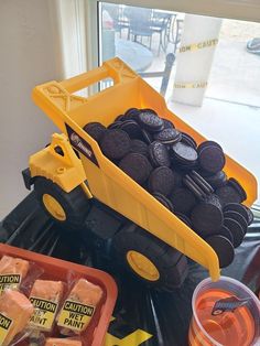 a yellow truck filled with oreos sitting on top of a table next to orange containers