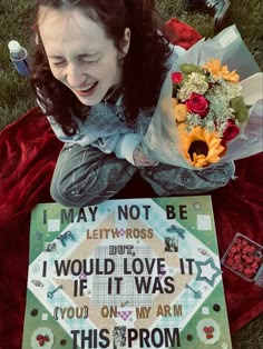 a woman sitting on the ground with flowers and a sign that says, may not be left - ross would love it if it was