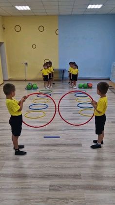 three young children playing with large hoop rings