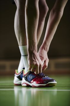 a man tying his shoes on the court