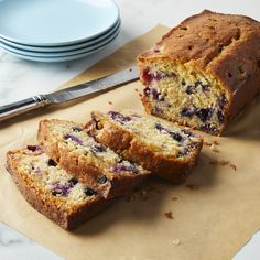 a loaf of blueberry muffin cut in half on top of a cutting board