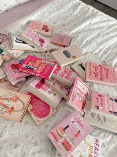 there are many pink books on the bed