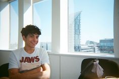 a man sitting in front of a window with his arms crossed