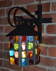 a colorful light hanging from the side of a brick wall