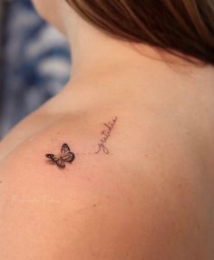 a woman with a butterfly tattoo on her back shoulder and the word love is written in cursive writing