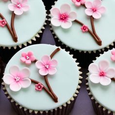 the cupcakes are decorated with pink flowers