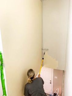 a woman is painting the walls in her home