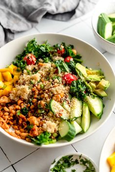 a white bowl filled with lots of food on top of a tiled counter next to other bowls