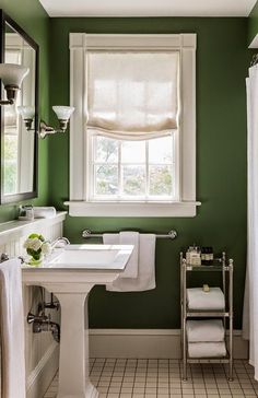 a bathroom with green walls and white fixtures