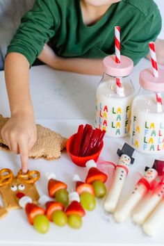 a little boy is making some food at the table