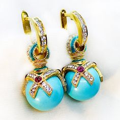 These marvelous high-quality earrings were inspired by and designed in a Faberge style. The 14mm turquoise balls are set in an engraved 24k gold plated sterling silver top with an elegant, crisscross geometric design that is decorated with chains of Premium Crystals. Additionally, there are three 2.5mm genuine cabochon garnets at the center of each intersection, giving this design a bright and beautiful accent. The transparent turquoise enamel on the bails also matches the stone. Together with the sterling silver and cubic zirconia hoops, the earrings are approximately 1.2" in height and come with a jewelry box. I am a professional jewelry designer, who graduated from Saint Petersburg's Art and Design Academy. Immigrating to the USA, I brought back Faberge's style and traditional art with Luxury Sterling Silver Earrings With Gemstone Accents, Egg Earrings, Faberge Jewelry, Faberge Egg, Professional Jewelry, Silver Tops, Bright And Beautiful, Jewelry Designer, Schmuck Design