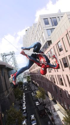 a large spider man statue is in the air above a city street with cars and buildings