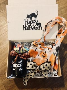 an open halloween gift box on top of a wooden table next to a black and white bag