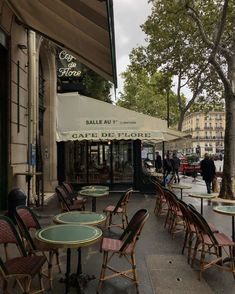 tables and chairs are lined up on the sidewalk outside an outdoor cafe in paris, france