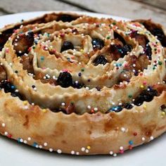 a white plate topped with a pastry covered in sprinkles