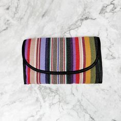 Our Wallet Shoulder Purse comes in several colors. Handmade and Fair Trade, this clever bag has a large zippered pocket, 9 credit card slots, a see-through ID slot, an interior pocket roomy enough for your checkbook, and even a loop to hold your pen! The long, corded strap can be hung over your shoulder or cross-body for added versatility. The Velcro closure keeps items secure. Guaranteed to be your new favorite bag! Bag: 7"W x 5"H (Folded) Strap: 52" 100% Cotton 1 Clear ID Pocket 9 Credit Card Foldable Rectangular Wallet For Daily Use, Multicolor Foldable Everyday Bags, Multicolor Cosmetic Bag With Removable Pouch, Everyday Multicolor Foldable Bags, Travel Coin Purse With Card Slots, Travel Clutch Wallet With Interior Card Slots, Travel Wallet Clutch With Mobile Phone Bag, Travel Clutch Cosmetic Bag With Phone Holder, Multicolor Clutch For Everyday Use With Mobile Phone Bag