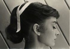 an old photo of a woman with a bow in her hair