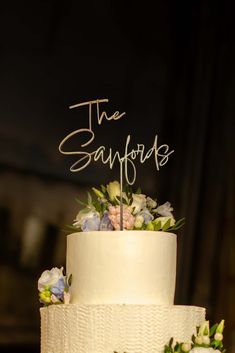 a three tiered cake with flowers and the words the samfobs on top