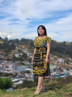 a woman standing on top of a lush green hillside