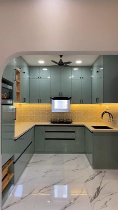 a kitchen with marble counter tops and green cabinets