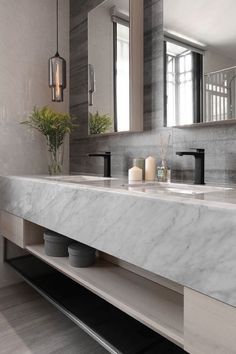 a bathroom with marble counter tops and double sinks