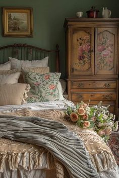 a bed in a bedroom with green walls and flowers on the headboard, along with an old dresser