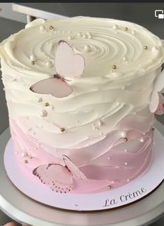 a pink and white cake with butterflies on it