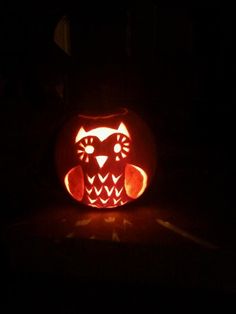 an owl carved into a pumpkin in the dark