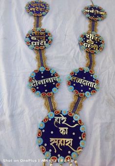 two blue and gold necklaces with words written in different languages on the bottom one