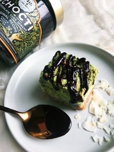 a white plate topped with a piece of cake next to a bottle of booze