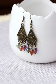 Feminine boho earrings with multicolored czech glass 6 mm beads (green,purple,orange-brown), antique brass chandelier charms and antique brass earring hooks. Earring hooks are from nickel free and lead free metal. Perfect jewelry your unique boho style outfit or a great gift for someone special! *The total lenght of earrings is about 60 mm including earring hooks. Other earrings of my shop you can see here: https://www.etsy.com/shop/NaTavelli?section_id=13757927 Thanks for visit. Bohemian Crystal Earrings With Faceted Beads For Gift, Bohemian Nickel Free Crystal Drop Earrings, Bohemian Nickel-free Drop Crystal Earrings, Bohemian Crystal Drop Earrings With Ear Wire, Bohemian Crystal Earrings With Faceted Beads, Adjustable Metal Earrings With Faceted Beads, Bohemian Style Chandelier Earrings With Faceted Beads, Bohemian Dangle Earrings With Faceted Beads, Bohemian Chandelier Earrings With Faceted Beads