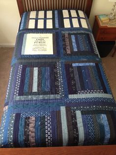 a bed with a blue quilt on top of it