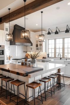 a large kitchen with an island in the middle and stools at the counter top