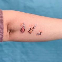 a woman's arm with two small tattoos on the left side of her arm