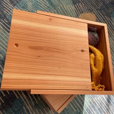 an open wooden box sitting on top of a carpet