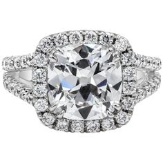 a cushion cut diamond surrounded by halos and pave set in 18k white gold