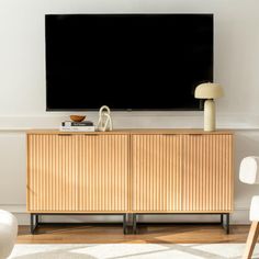 a flat screen tv mounted to the side of a wooden cabinet in a living room