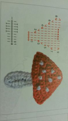 a crocheted strawberries on top of a paper with measuring lines in the background