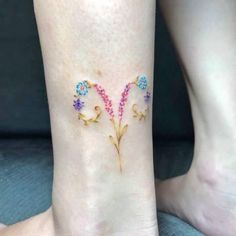 a woman's foot with a flower tattoo on the left side of her leg