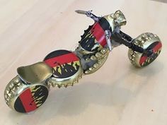 the skateboard is made out of metal and has red, yellow and black wheels