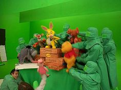 a group of people dressed up as winnie the pooh and friends in front of a green screen