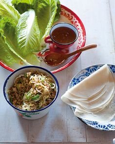 two bowls filled with food sitting on top of a table next to some lettuce