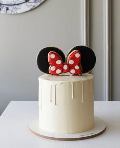 a white cake topped with mickey mouse ears