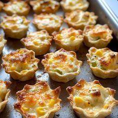 many small quiche cups are on a baking sheet