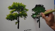 someone is drawing trees with pencils on paper