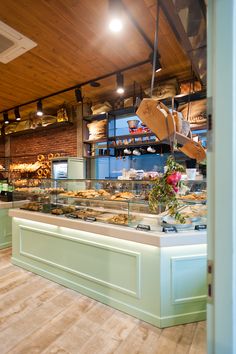 a bakery filled with lots of pastries on display in front of a wooden ceiling