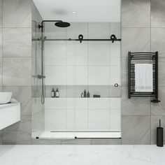 a bathroom with marble walls and flooring, including a walk - in shower next to a white sink