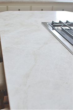 a white counter top with a stove and oven in the backgrounf area