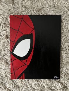 a spiderman face painted on a black and red canvas