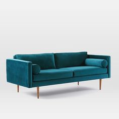 a teal colored couch with wooden legs and arm rests on an isolated white background